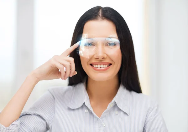 Mulher sorridente apontando para óculos futuristas — Fotografia de Stock