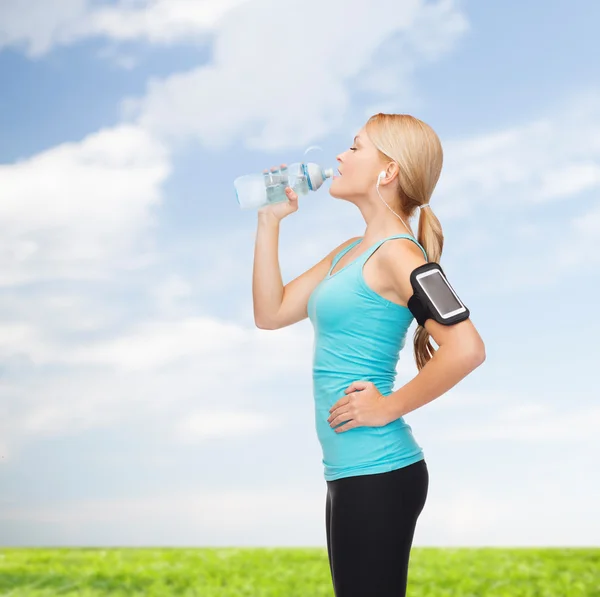 Mujer deportiva corriendo con smartphone y auriculares — Foto de Stock