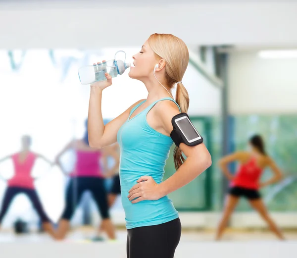 Mujer deportiva corriendo con smartphone y auriculares — Foto de Stock