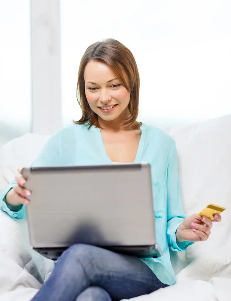 Mulher sorridente com computador portátil em casa — Fotografia de Stock