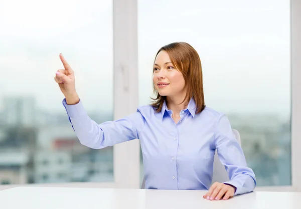 Smiling woman pointing to something imaginary — Stock Photo, Image