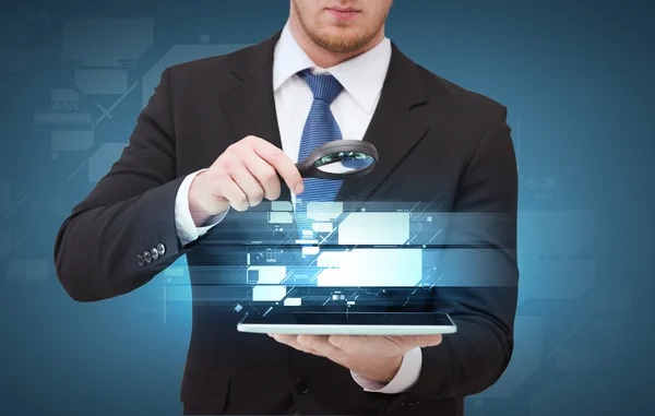 Businessman hand holding magnifier over tablet pc — Stock Photo, Image