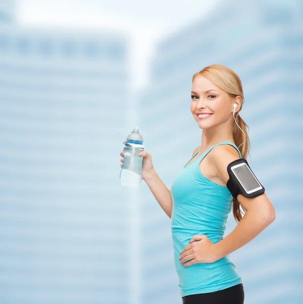 Mujer deportiva corriendo con smartphone y auriculares —  Fotos de Stock