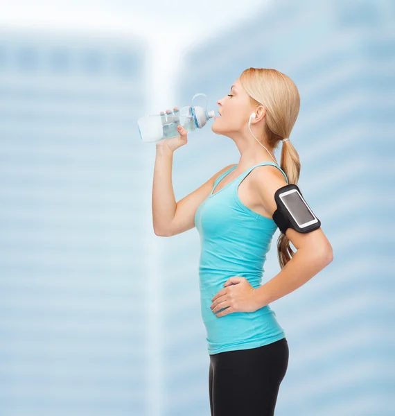 Mujer deportiva corriendo con smartphone y auriculares — Foto de Stock