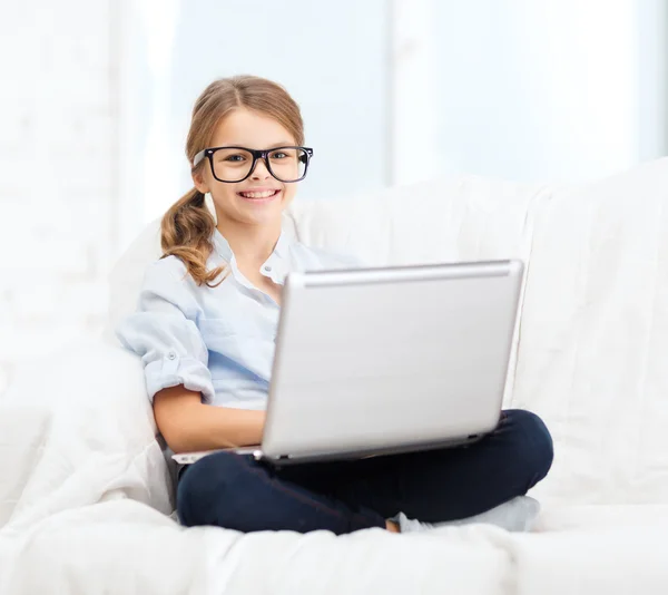 Sonriente chica en las especificaciones con ordenador portátil en casa — Foto de Stock