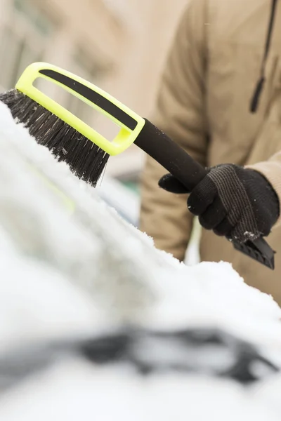 Närbild av man rengöra snö från bilen — Stockfoto