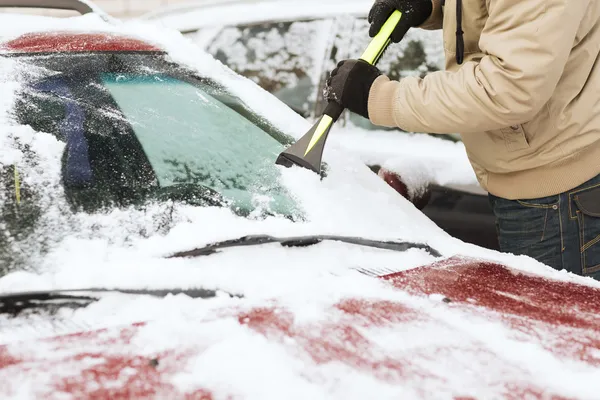 Nahaufnahme eines Mannes, der Eis von Auto kratzt — Stockfoto