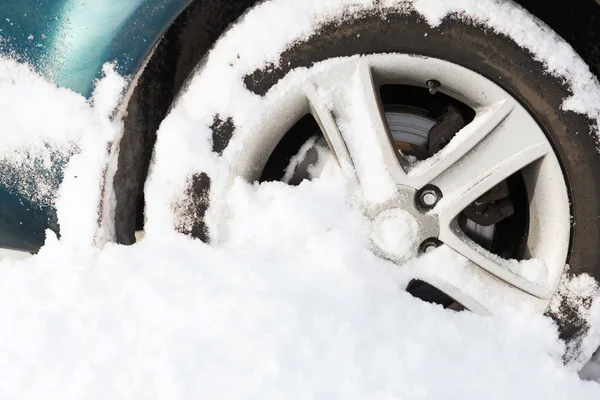 雪の中で立ち往生している車のホイールのクローズ アップ — ストック写真