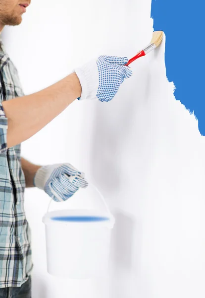 Hombre con pincel y pared de pintura en maceta — Foto de Stock