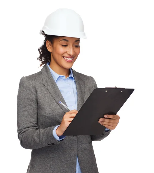 Businesswoman in white helmet with clipboard — Stock Photo, Image