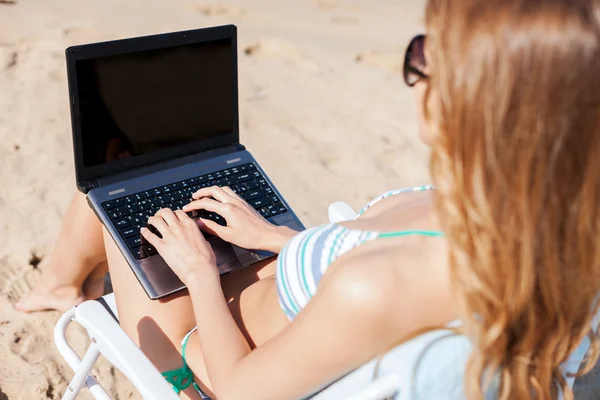 Menina olhando para laptop na praia — Fotografia de Stock