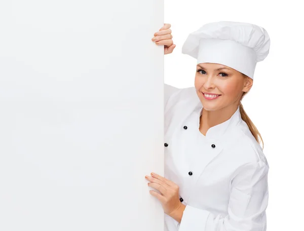 Chef feminino sorridente com placa branca em branco — Fotografia de Stock