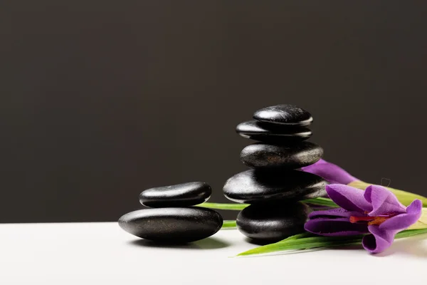 Massage stones with flowers on mat — Stock Photo, Image