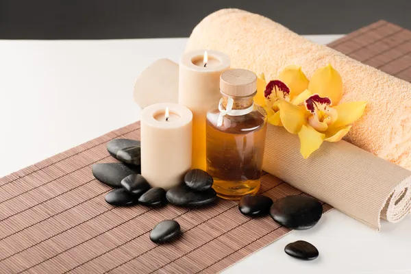 Ätherisches Öl, Massagesteine und Orchideenblume — Stockfoto