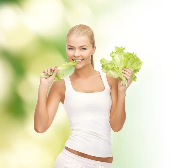 Mujer sonriente mordiendo lechuga —  Fotos de Stock