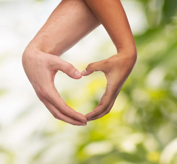 Manos de hombre y mujer mostrando forma de corazón — Foto de Stock