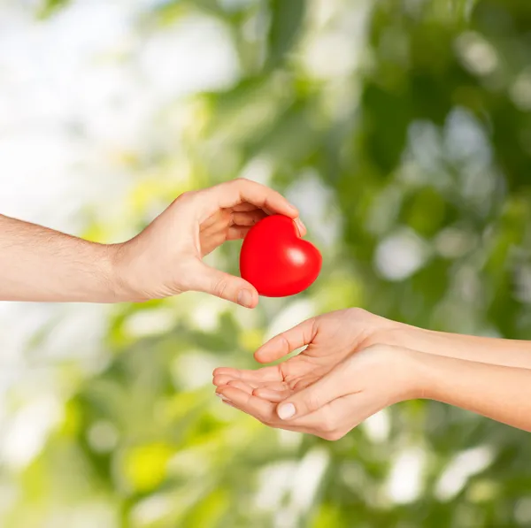 Man hand giving red heart to woman — Stock Photo, Image