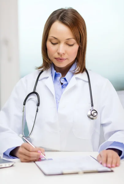 Busy doctor with laptop computer and clipboard — Stock Photo, Image