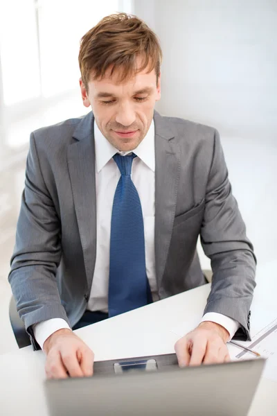 Businessman with laptop computer and documents — Stock Photo, Image