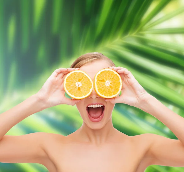 Erstaunte junge Frau mit Orangenscheiben — Stockfoto