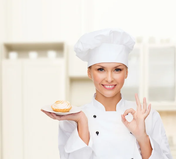 Lachende vrouwelijke chef-kok met taart op plaat — Stockfoto