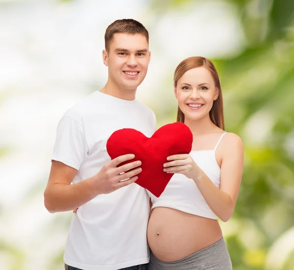 Felice giovane famiglia in attesa di bambino con grande cuore — Foto Stock