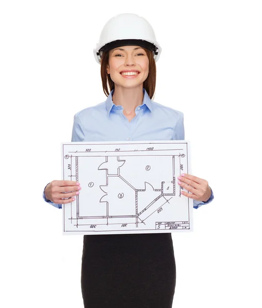 Smiling businesswoman in helmet showing blueprint — Stock Photo, Image