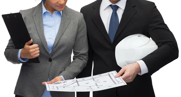 Businesspeople with blueprint and helmet — Stock Photo, Image