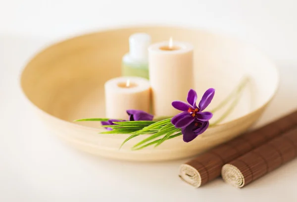 Velas e flores de íris em intestino e esteira de madeira — Fotografia de Stock