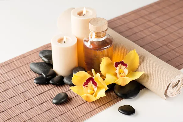 Ätherisches Öl, Massagesteine und Orchideenblume — Stockfoto