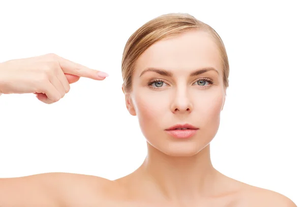 Woman pointing at her face — Stock Photo, Image