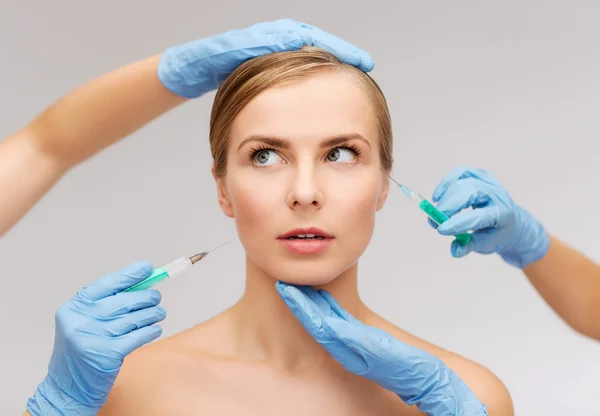 Woman face and beautician hands with syringe — Stock Photo, Image