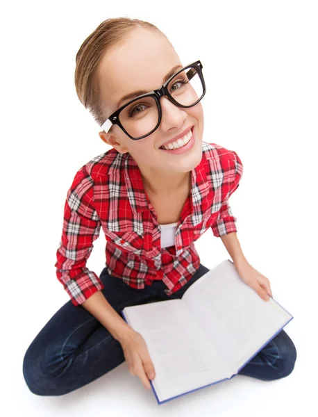 Lachende tienermeisje in brillen lezen van boek — Stockfoto