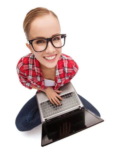 Smiling teenage girl in eyeglasses with laptop — Stock Photo, Image