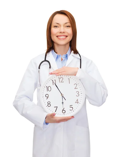 Smiling female doctor with wall clock — Stock Photo, Image