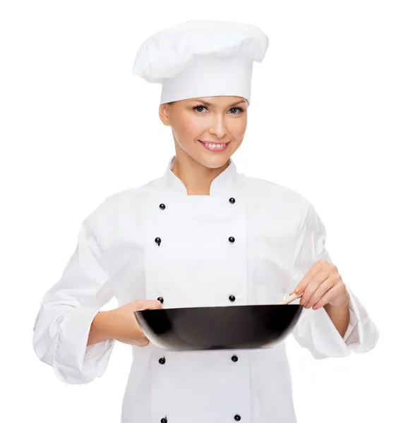 Pan ve kaşık ile gülümseyen kadın aşçı — Stok fotoğraf