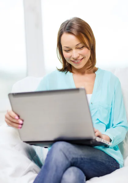 Mujer sonriente con ordenador portátil en casa — Foto de Stock