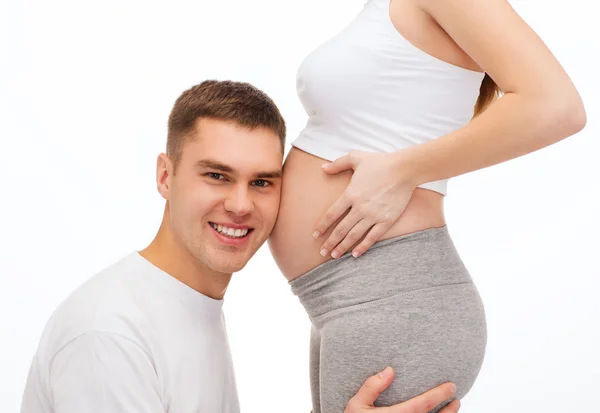 Père heureux écoutant le ventre de sa femme enceinte — Photo