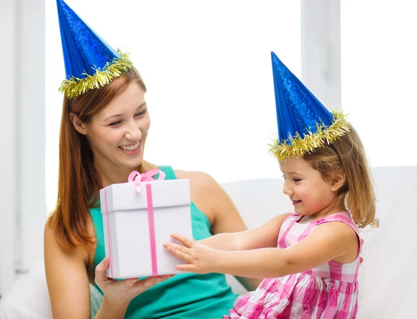 Mother and daughter in blue hats with favor horns — Stock Photo, Image