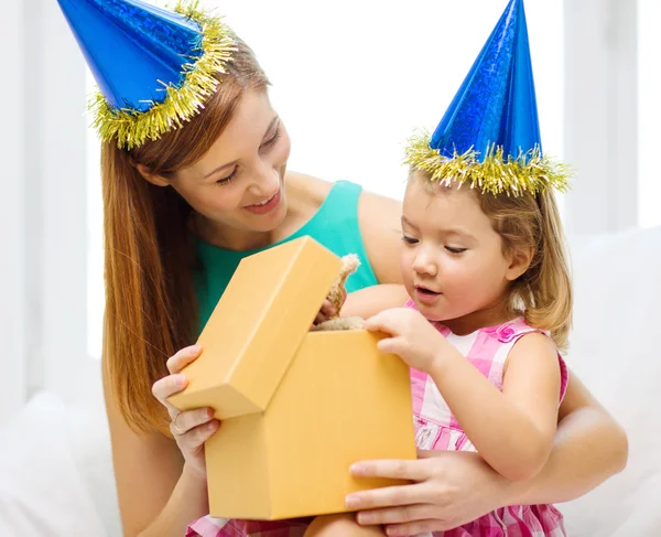 Mother and daughter in blue hats with favor horns — Stock Photo, Image