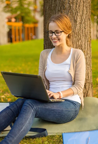 Adolescente sonriente en gafas con portátil — Foto de Stock