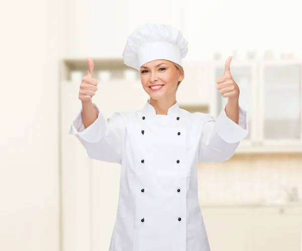 Sorridente chef femminile mostrando pollici in su — Foto Stock