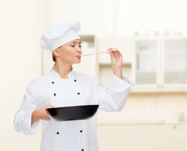 Chef feminino sorridente com panela e colher — Fotografia de Stock