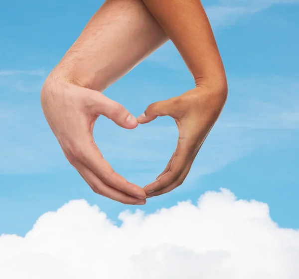 Manos de hombre y mujer mostrando forma de corazón — Foto de Stock