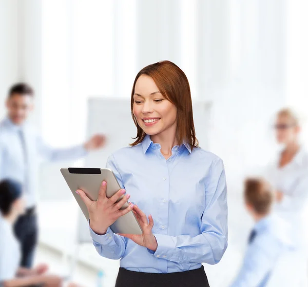Lachende vrouw kijken naar tablet pc op kantoor — Stockfoto