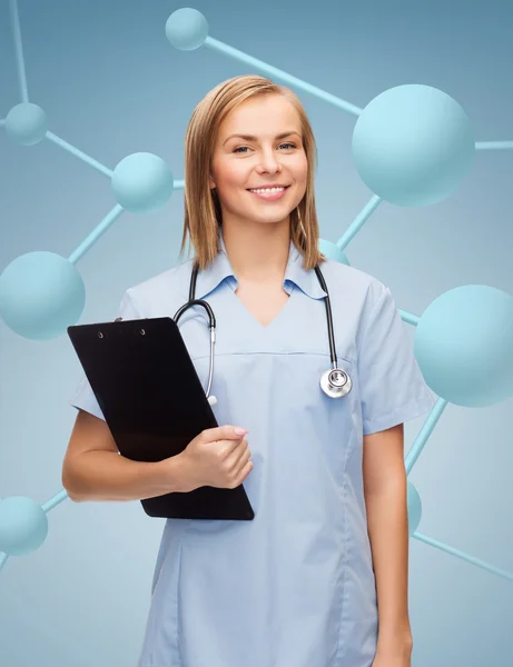 Smiling female doctor or nurse with clipboard — Stock Photo, Image