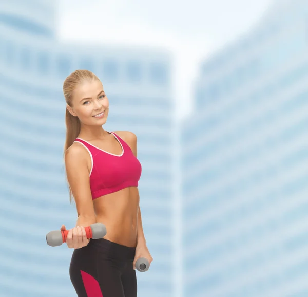 Young sporty woman with light dumbbells — Stock Photo, Image