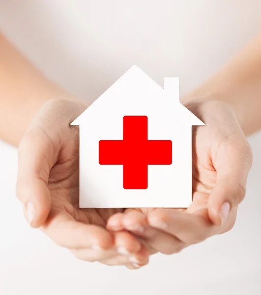 Hands holding paper house with red cross — Stock Photo, Image