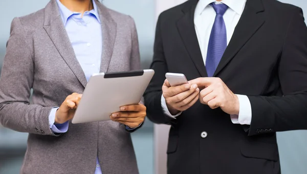 Two businesspeople with smartphone and tablet pc — Stock Photo, Image