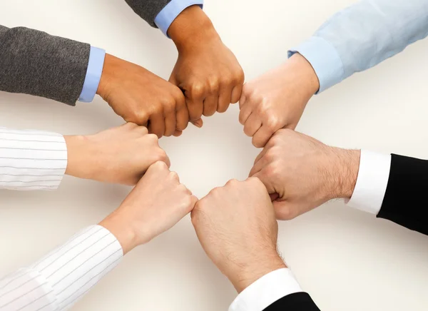 Closeup of businesspeople hands in fists in circle — Stock Photo, Image